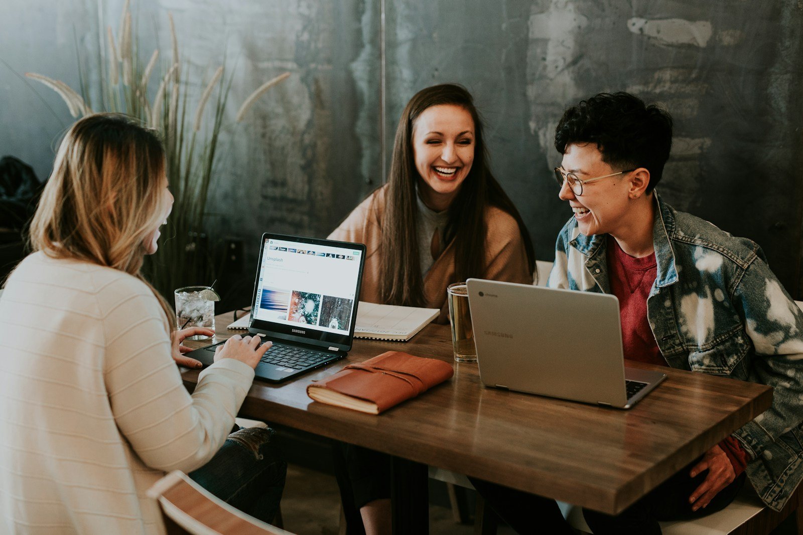 Three colleagues reviewing work together at a table